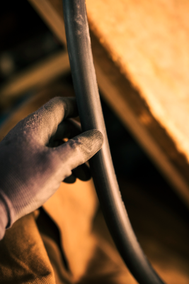 source-de-chaleur-installateur-cable-chauffage-bois artisan-avec-gants-tenant-cable-dans-atelier