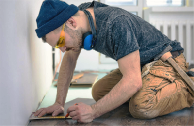 source-de-chaleur-installateur-poseur-chauffage-bois artisan-accroupi-marquant-le-solpour-decoupe